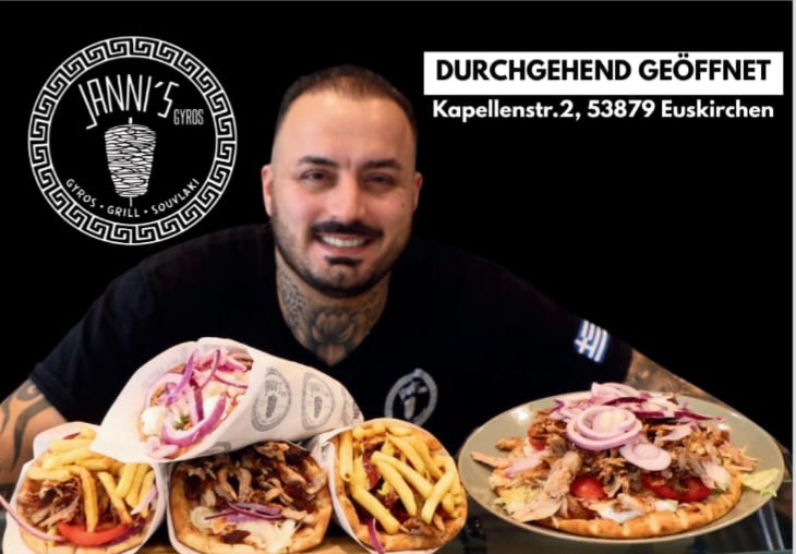 Ein lächelnder Mann mit dunklen Haaren sitzt hinter Gyrosgerichten mit Pommes und Zwiebeln