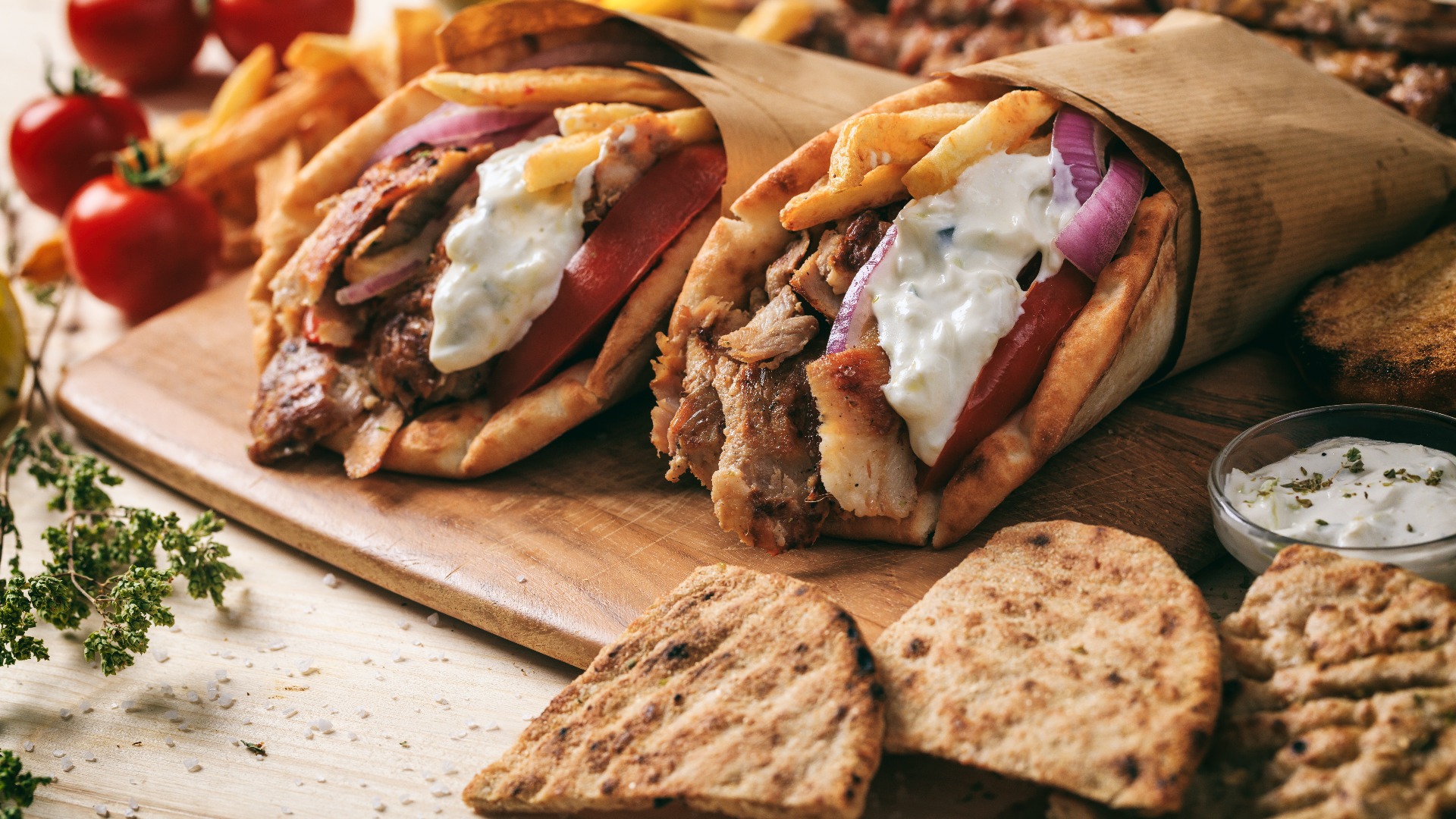 Greek gyros wrapped in pita breads on a wooden table